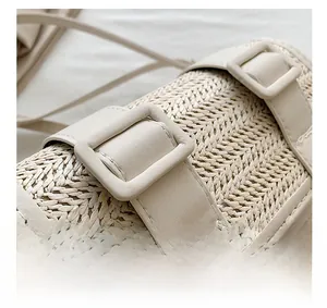 Detail of woven straw texture and cream leather strap on a minimalist crossbody bag