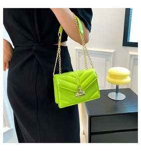 Dettaglio borsa chevron verde neon con tracolla a catena dorata e chiusura a scatto