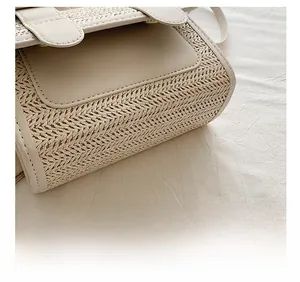 Close-up of the delicate straw weaving and premium faux leather stitching on the beige bag