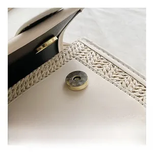 Detail of golden magnetic snap button and woven texture on contrast stitching bag