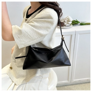 Minimalist black baguette shoulder bag with adjustable strap and sleek zipper detail
