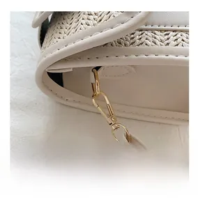 Detail of light beige leather and woven straw textures with gold-tone metal buckle