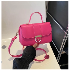 Detail of hot pink PU leather handbag with gold buckle and adjustable shoulder strap