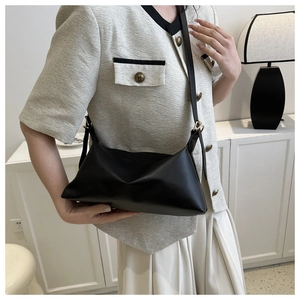 Detailed close-up of a minimalist black PU leather crossbody bag with adjustable strap