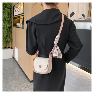 Detail of mini crossbody bag with pink contrast trim and patterned ribbon handle