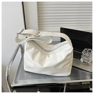 Detail view of the white minimalist leather crossbody bag with wide adjustable strap