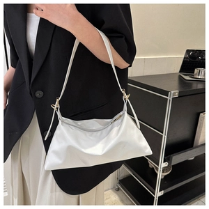 Close-up of minimalist white soft PU leather baguette bag with sleek metal hook detail