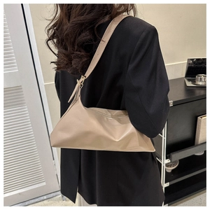 Macro detail of soft beige PU leather shoulder bag featuring pleated texture and strap