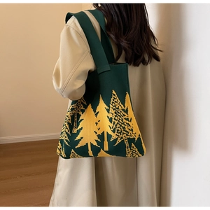 Detail view of large knit tote bag with dark green and yellow pine tree patterns