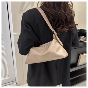 Detail of beige hobo bag showing soft leather texture and golden metal buckle accents
