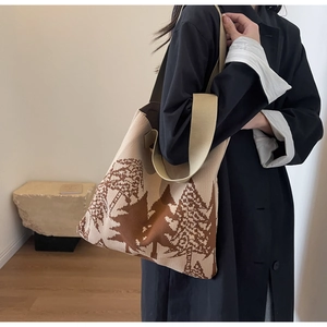 Detail of knit tote bag featuring brown pine forest jacquard pattern and wide shoulder strap