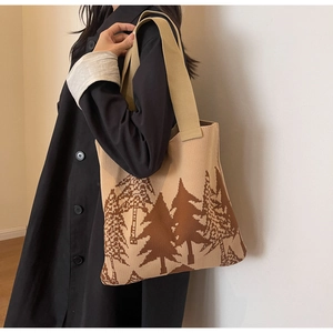 Detail of the knit tote bag featuring a brown forest tree pattern on beige fabric