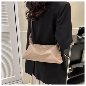 Detail of adjustable shoulder strap and smooth PU leather on a tan minimalist handbag