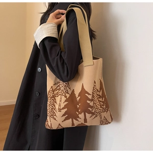 Detail of knit tote bag featuring contrast forest pine pattern and wide shoulder strap