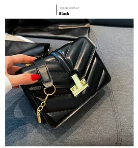 Dettaglio borsa in pelle nera trapuntata con cuciture a V e chiusura in metallo