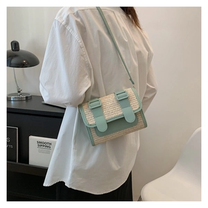 Close-up of mint green and cream woven crossbody bag shown on model in lifestyle setting