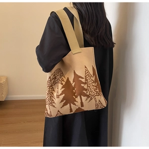 Detail of knit tote bag featuring beige and brown pine tree patterns with wide shoulder strap