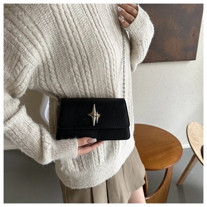 Close-up of black rectangular crossbody bag featuring a silver star buckle and chain