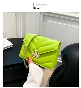 Dettaglio borsa quadrata verde neon trapuntata con fibbia dorata e tracolla a catena