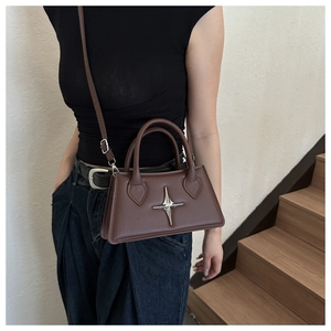 Detailed view of dark brown crossbody bag featuring iconic silver star metal ornament