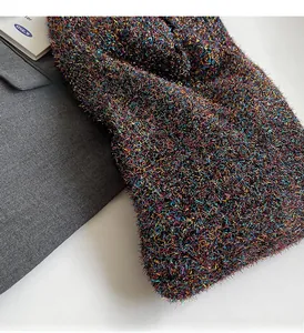 Close-up of glittery knit fabric showing colorful metallic fibers on a grey blazer
