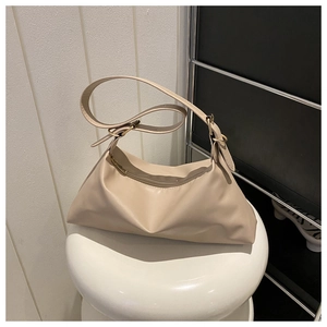 Detailed close-up of cream soft PU leather texture and golden metal ring on shoulder bag