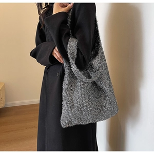 Detailed close-up of metallic knit texture and silver shiny fabric on a shoulder tote bag