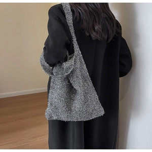 Silver knit tote bag with metallic threads shown from the back perspective on a model