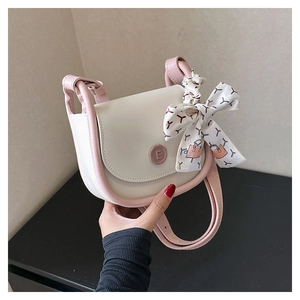 Detail of contrast color crossbody bag featuring decorative printed ribbon bow and E-logo