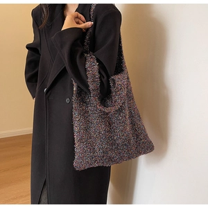 Close-up of colorful sparkling knit shoulder bag texture on black coat background