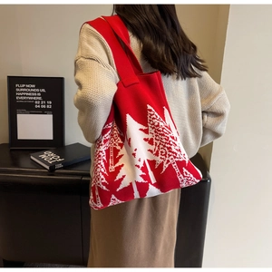 Detail of red knit tote bag with white forest pattern and festive winter texture