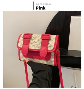 Detail of hand-woven straw crossbody bag with pink leather flap and dual buckle closure