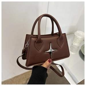 Close-up of brown star crossbody bag with silver hardware and detachable strap