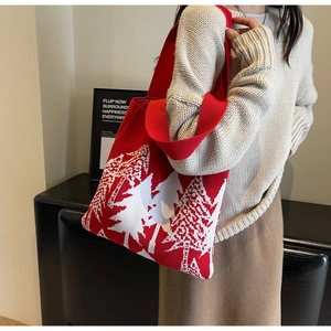 Close-up of red and white knit tote bag with festive tree pattern and wide shoulder straps