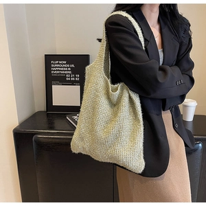 Close-up of sparkling gold knit shoulder bag texture with soft woven metallic fabric