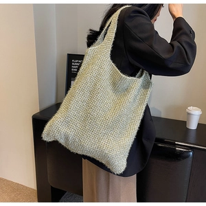 Detail of soft metallic gold knit shoulder bag with textured woven pattern and spacious design