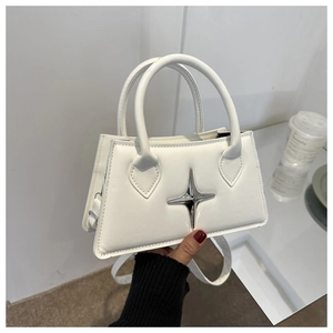 Detail view of a white faux leather crossbody bag featuring silver star metal ornaments