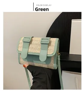 Detail of green straw woven messenger bag with faux leather flap and gold hardware