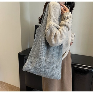 Detail of silver knit tote bag with metallic threads shown on model shoulder