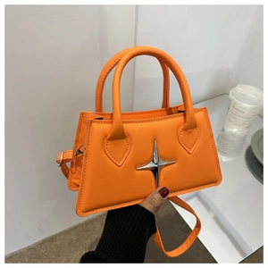 Detail of orange leather handbag with a silver star metal ornament and adjustable strap