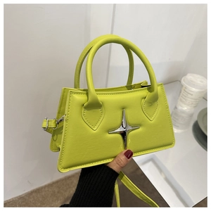 Detail of neon green mini tote bag featuring a silver star metal clasp and smooth leather