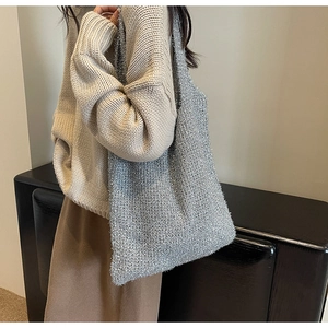 Detail of silver knitted tote bag with shimmering metallic threads and soft texture