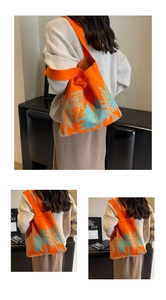 Detail of orange knitted tote bag featuring light blue tree patterns and thick knit texture