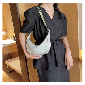 Dettaglio della tracolla regolabile in nylon e cerniera di una borsa hobo grigia a mezzaluna