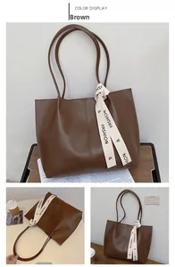 Detail view of large brown faux leather tote bag with decorative fashion ribbon
