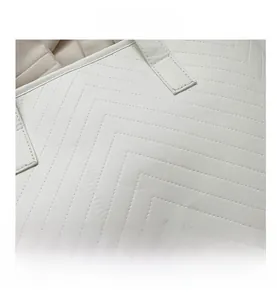 Detail view of the white tote bag showing premium V-shaped chevron quilting and fine stitching