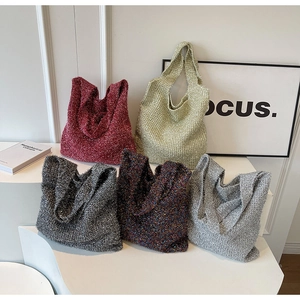Close-up of knit shoulder bags in red, green, and grey with textured woven fabric