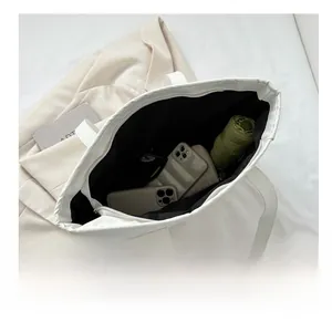 Top-down view of a spacious white tote bag showing capacity for a phone, wallet, and umbrella
