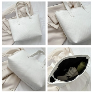 Detail view of white V-quilted tote bag featuring inner lining and fine PU leather texture