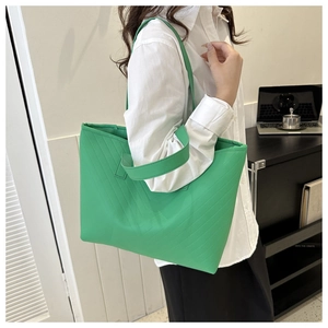 Detail showing the bright green tote bag with V-shaped quilted texture for work